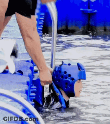 A Person In A Blue Helmet Is Being Pulled Out Of The Water GIF