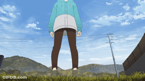 A Person In A Blue Hoodie And Brown Pants Standing In The Grass GIF