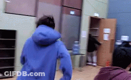 A Person In A Blue Jacket Is Running In A Room GIF