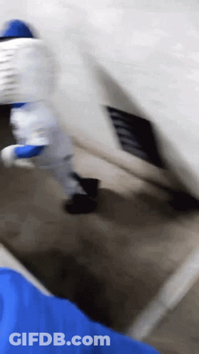 A Person In A Blue Shirt Is Holding A White Object GIF