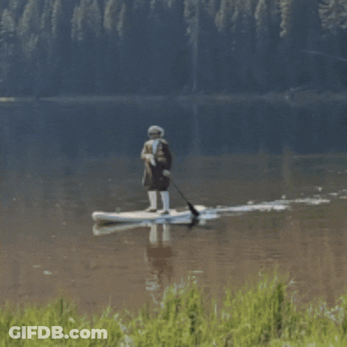 A Person In A Boat On A Lake In The Mountains GIF