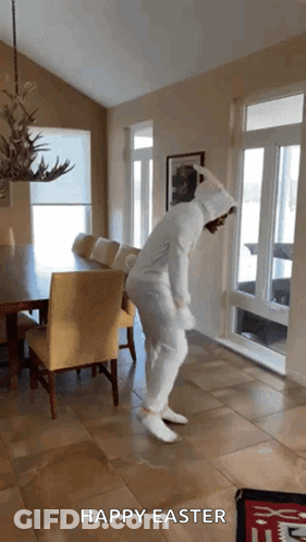 A Person In A Bunny Costume Is Dancing In A Room With The Words Happy Easter Below Them GIF