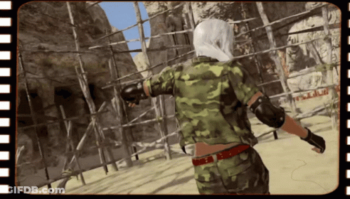 A Person In A Camouflage Uniform Is Standing In Front Of A Sign That Says ' A.m.p. ' GIF