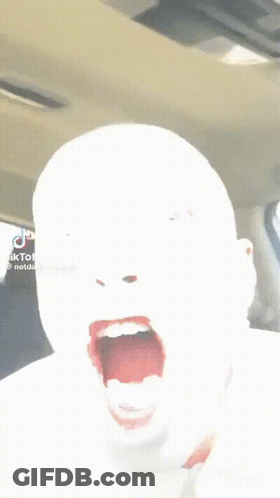 A Person In A Car With Their Mouth Open And Their Tongue Hanging Out GIF
