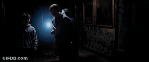 A Person In A Dark Room Holding A Light In Their Hand GIF