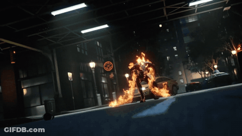 A Person In A Fire Suit Is Standing On A Street GIF