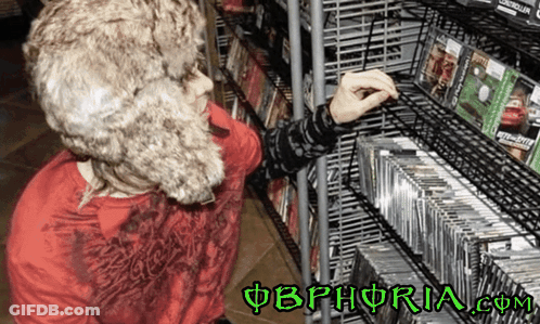 A Person In A Fur Hat Is Looking At Cds On A Shelf With The Website Obphoria.com In The Corner GIF