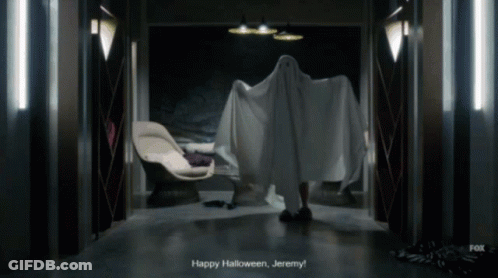 A Person In A Ghost Costume Says " Happy Halloween Jeremy " In A Dark Hallway GIF