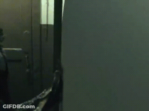 A Person In A Hoodie Is Standing In A Dark Room GIF