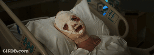 A Person In A Hospital Bed With A Bandaged Face GIF