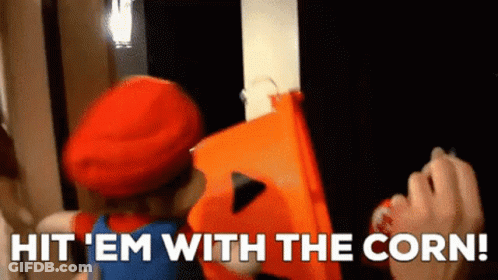 A Person In A Mario Costume Is Holding An Orange Bucket And Says Hit ' Em With The Corn . GIF