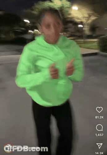 A Person In A Neon Green Hoodie Is Dancing In A Blurry Photo With A Caption That Says Iam.miramarie GIF