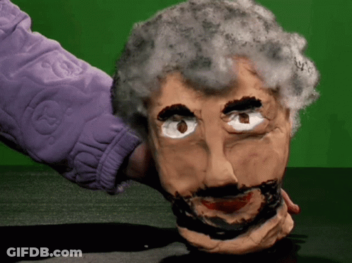 A Person In A Purple Jacket Is Holding A Puppet Head GIF
