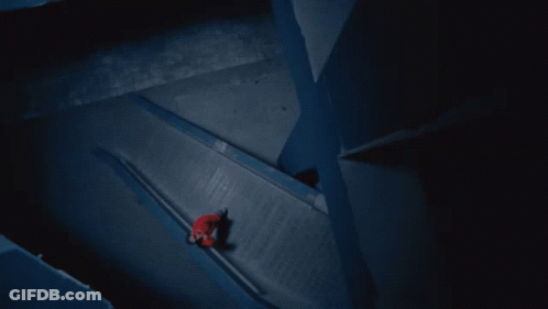 A Person In A Red Jacket Is Walking Down A Staircase GIF