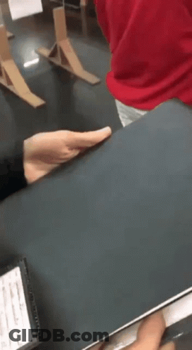 A Person In A Red Shirt Is Holding A Black Book In Their Hands . GIF