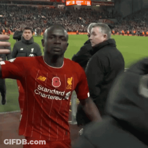A Person In A Red Shirt Is Standing In Front Of A Red Wall . GIF