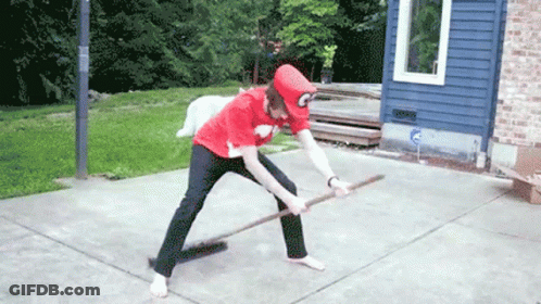 A Person In A Red Shirt With The Letter C On It Is Holding A Broom GIF
