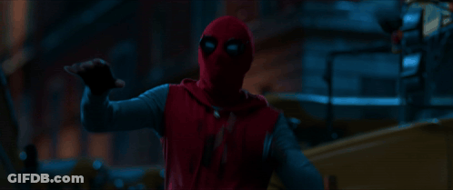 A Person In A Red Spiderman Costume Is Pointing At Something In The Dark GIF