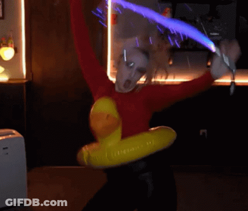 A Person In A Red Sweater Is Holding A Sword And A Yellow Duck Float GIF