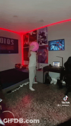 A Person In A Room With A Pink Balloon On Their Head And A Sign That Says Solo GIF