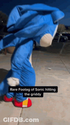 A Person In A Sonic The Hedgehog Costume Is Dancing On A Sidewalk . GIF