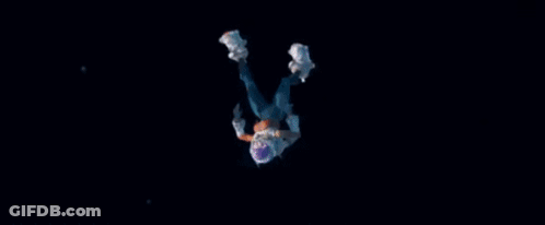 A Person In A Space Suit Is Falling Through The Air In The Dark . GIF
