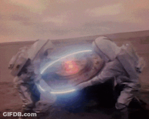A Person In A Space Suit Is Holding A Glowing Object In Their Hands GIF
