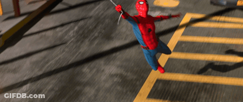 A Person In A Spiderman Costume Is Flying Over A Parking Lot GIF