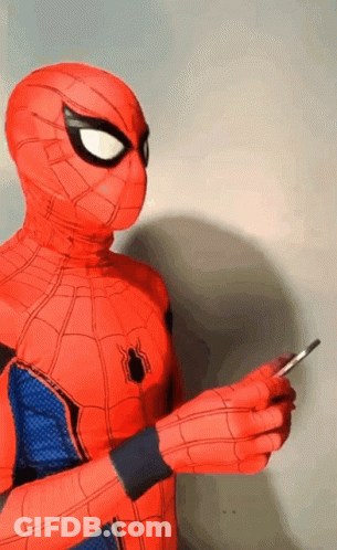 A Person In A Spiderman Costume Is Holding A Cell Phone In Their Hand . GIF
