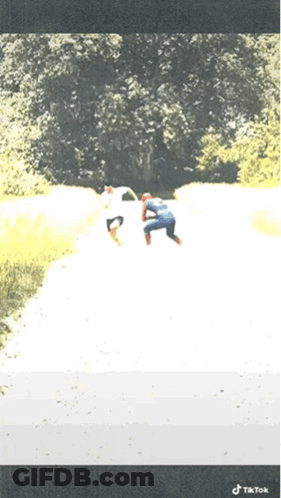 A Person In A Spiderman Costume Is Walking Down A Path GIF