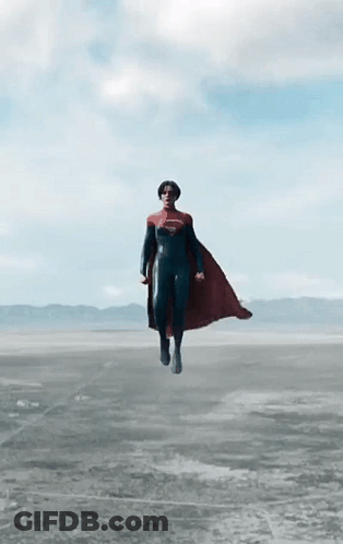 A Person In A Superman Costume Is Flying Through The Air GIF