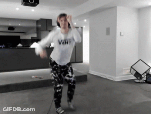 A Person In A Vans Shirt Is Dancing In A Room GIF
