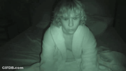 A Person In A White Robe Is Sitting On A Bed GIF
