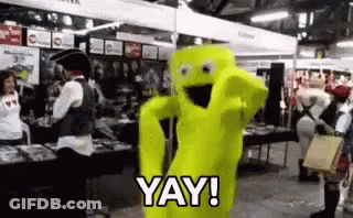A Person In A Yellow Costume Is Standing In A Crowded Room And Saying `` Yay ! '' GIF