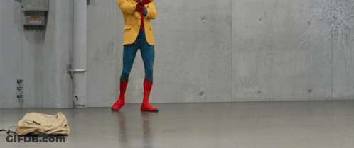 A Person In A Yellow Jacket Stands In Front Of A Wall With Snowflakes Drawn On It GIF
