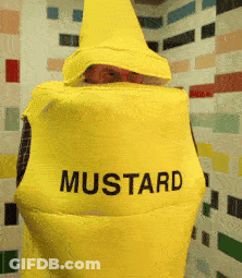 A Person In A Yellow Mustard Costume Is Standing In Front Of A Tiled Wall GIF