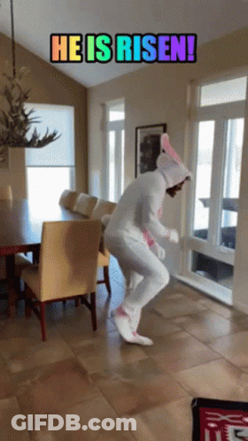 A Person In An Easter Bunny Costume Is Jumping In A Room With The Words He Is Risen GIF