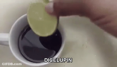 A Person Is Adding A Slice Of Lime Into A Cup Of Coffee . GIF