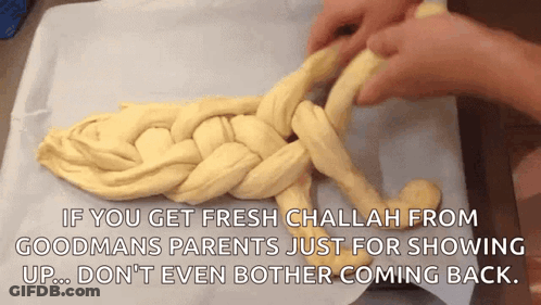 A Person Is Braiding A Loaf Of Challah Bread On A Table GIF