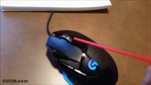 A Person Is Cleaning A Logitech Mouse With A Red Brush GIF