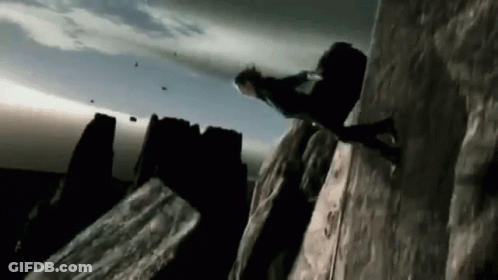 A Person Is Climbing Up A Rocky Cliff GIF