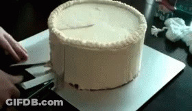 A Person Is Cutting A Cake With Scissors On A Cutting Board GIF