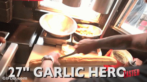 A Person Is Cutting A Loaf Of Bread With The Words 27 " Garlic Hero Master On The Bottom GIF