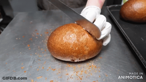A Person Is Cutting A Loaf Of Bread With The Words Made In Animatica Visible GIF