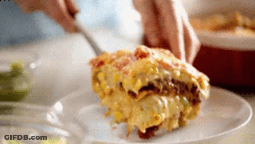 A Person Is Cutting A Piece Of Food On A Plate GIF