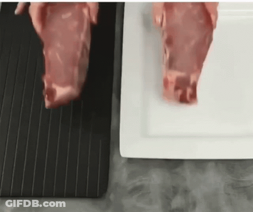 A Person Is Cutting A Piece Of Meat On A Black Cutting Board . GIF
