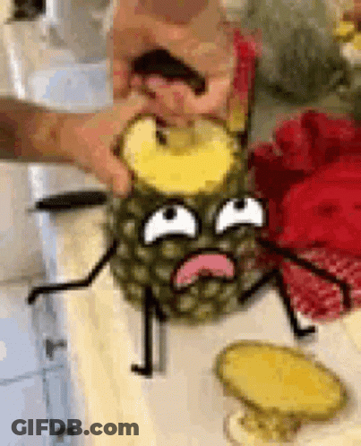 A Person Is Cutting A Pineapple With A Cartoon Face On It On A Table . GIF
