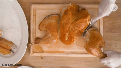 A Person Is Cutting A Turkey On A Cutting Board With The Number 52 On The Bottom Right GIF