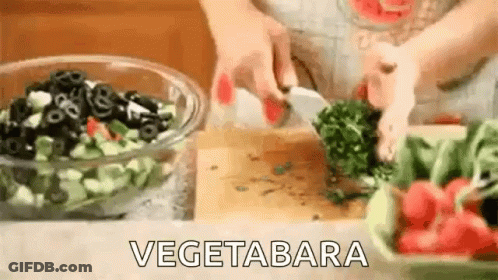 A Person Is Cutting Vegetables On A Cutting Board . GIF