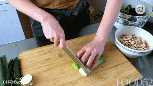 A Person Is Cutting Vegetables On A Wooden Cutting Board With The Number 52 In The Corner GIF